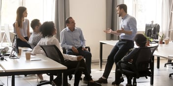 Group of 4 people chatting at a business meeting. 